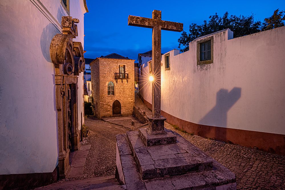 Europe-Portugal-Obidos-Church and cross on cobblestone street at sunset